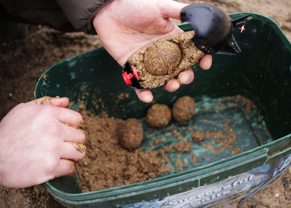 Den Rest Groundbait mache ich etwas flüssiger und fülle die Spomb damit auf!